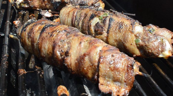 Bacon wrapped venison stuffed with cheese on a skewer