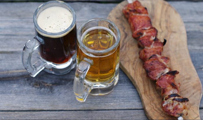 Grilled wild game meat and mug of beer